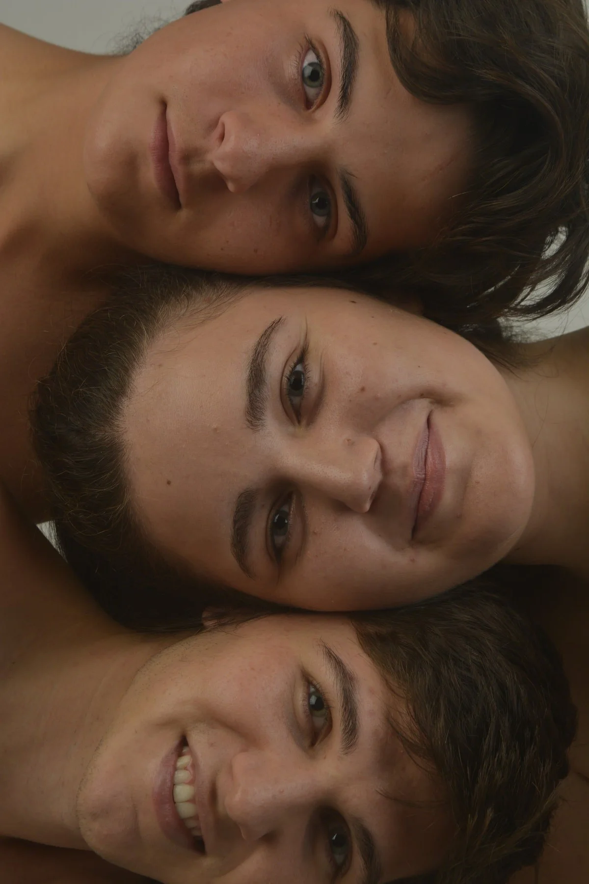 Tres modelos apilan sus rostros sonrientes en un retrato beauty