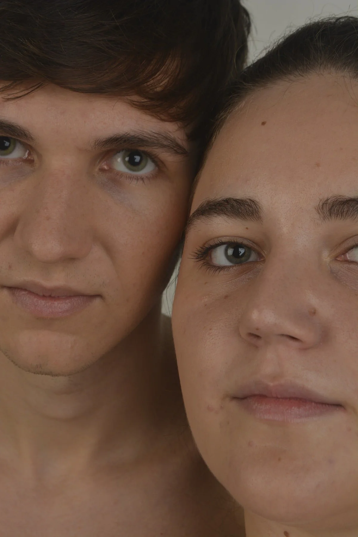 Retrato beauty de dos modelos con los rostros juntos sobre fondo gris